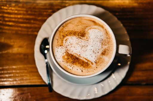 A top view of a cup of Cappuccino on a wooden table