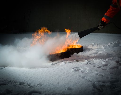 The hand of a firefighter putting out the fire on the snow