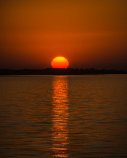 A golden sunset over the wavy sea water