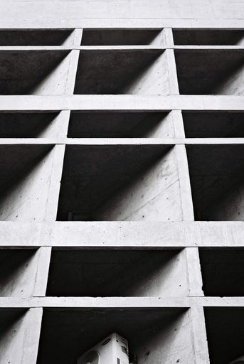 A low angle greyscale of brutalist architecture - a cool picture for wallpapers and backgrounds