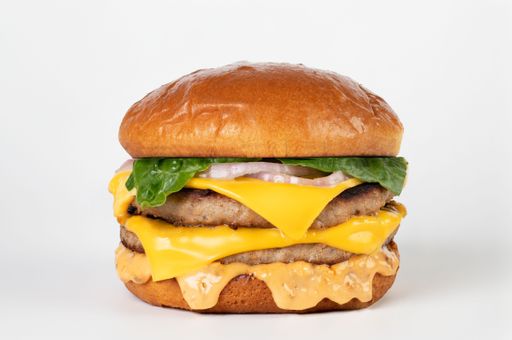 A closeup of a double beef burger with American cheese and brioche