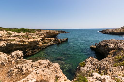 The Cave of Pillirina surrounded by the sea under the sunlight and a blue sky in Italy