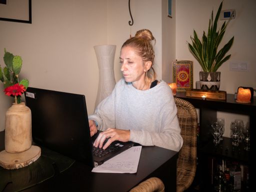 A closeup of an exhausted and stressed woman working from home on her laptop