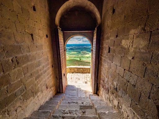 An amazing shot of a stone made historic building door opening with a picturesque landscape view