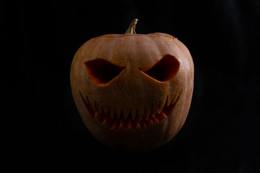 A closeup shot of Halloween pumpkin with a happy face on dark background