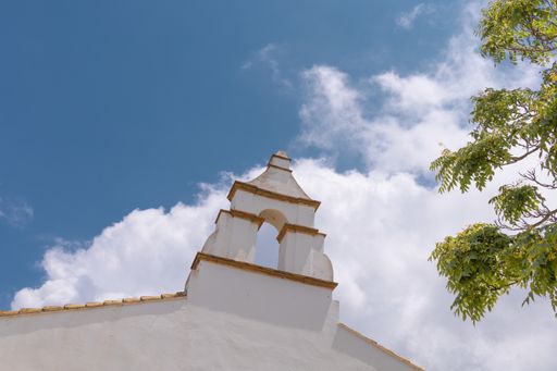 A low angle shot of a white historical building under cloudy sky