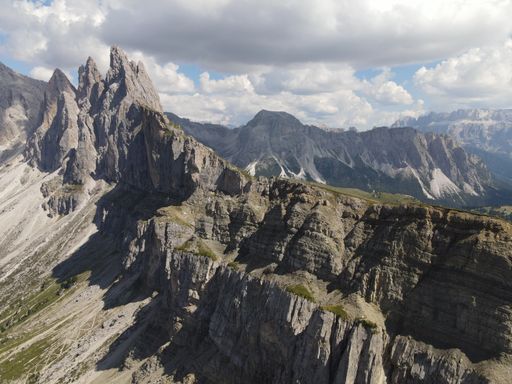 An aerial of Seceda Mountain under the sunlight and floating clouds in the Alps of Italy