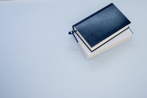 A closeup top view shot of blue and white books isolated  light blue background - copy space