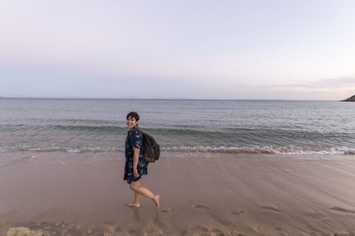 A young female walking at a white sand beach