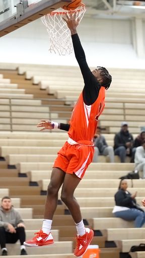 A vertical shot of a young male player dunking at a fall Merrillville high school basketball game