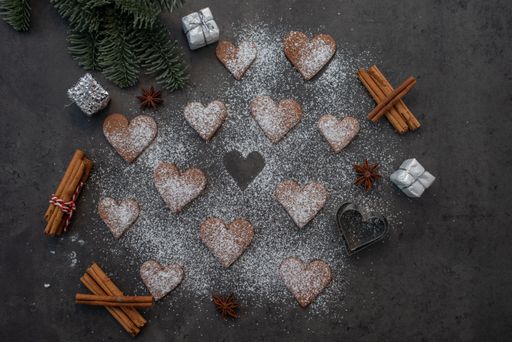 A top view of gingerbread heart-shaped cookies with sugar powder