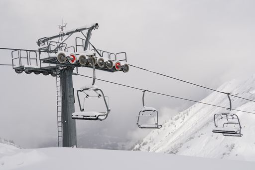 A shot of a ropeway covered with snow on foggy weather