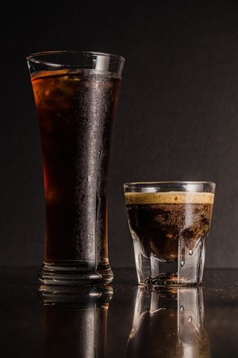 A vertical shot of glasses of liquor and coffee with reflections