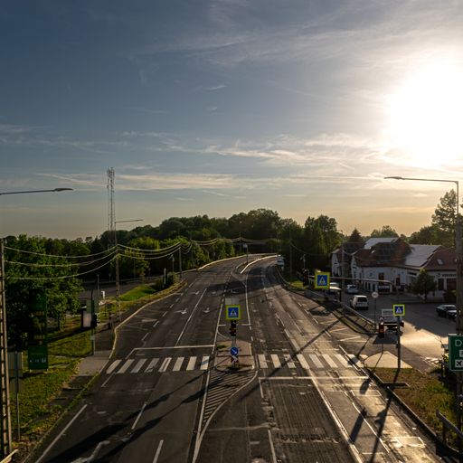 An aerial shot of the road in the residential area surrounded by lush trees