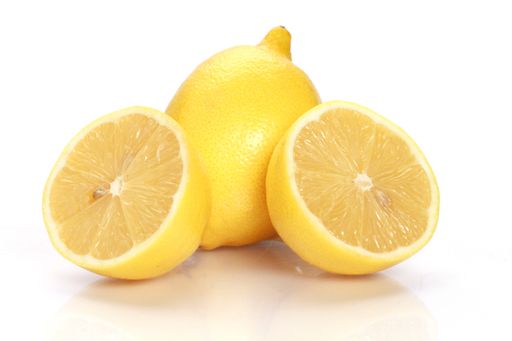 A closeup shot of halved lemons with a whole lemon isolated on a white background