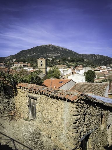 A vertical aerial shot of small buildings near mountains in Hinojosa de San Vicente, Toledo, Spain