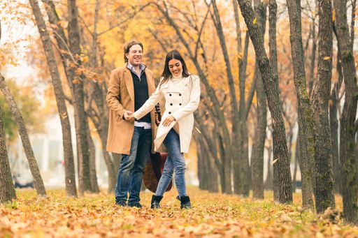 Young couple having fun in park in autumn