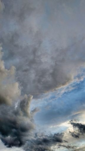 A vertical shot of a blue cloudy sky on a gloomy day - great for wallpapers