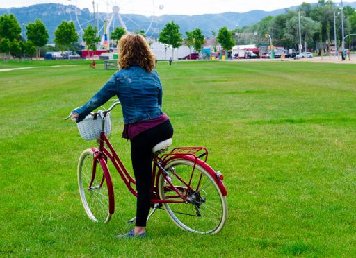 A back view of a female riding a bicycle in the park