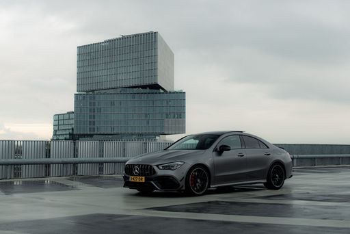 A matte grey Mercedes AMG car parked in front of modern building for a photoshoot