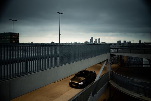 A matte grey Mercedes AMG car driving on a bridge road in Amsterdam