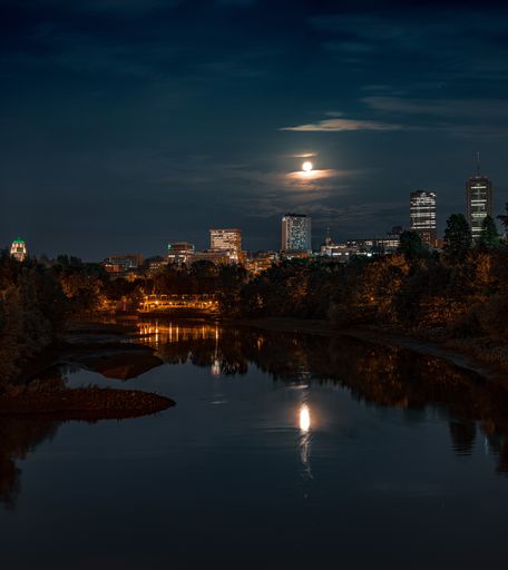 A shot of a river at night with Quebec City under a clear moonlit night