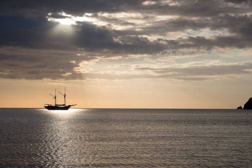An aerial view of boat sailing in sea during sunset