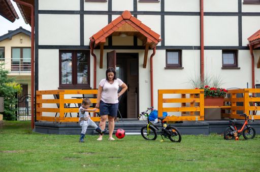 Woman and child standing in front of a vacation ho