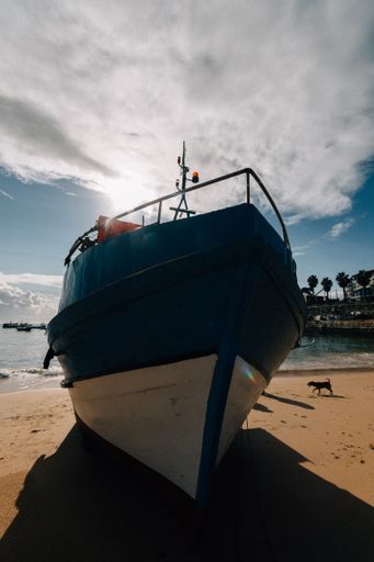 A vertical shot of a ship on the beach under cloudy sky in Portugal