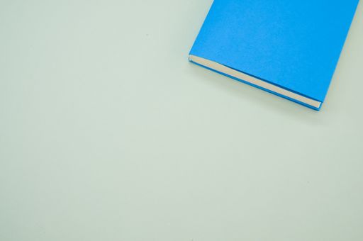 A top view of a blue hardcover book on the green surface - space for text