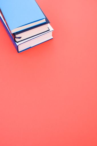 A closeup  of the hardcover books on the red surface - space for text