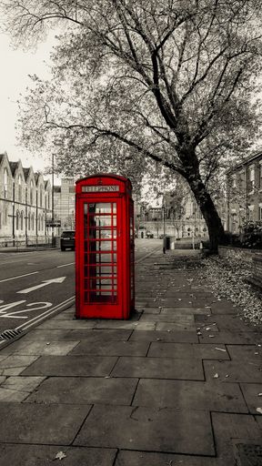 A red telephone box in street of London