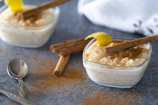 A closeup of a delicious rice pudding in a bowl with cinnamon sticks