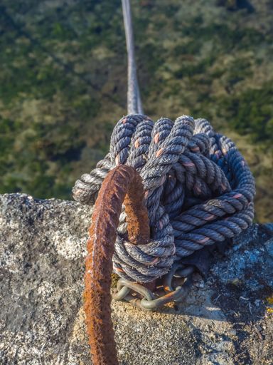 A vertical shot of a bollard and rope for mooring ships