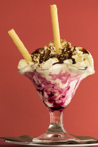 A vertical closeup shot of delicious-looking ice cream on an isolated red background