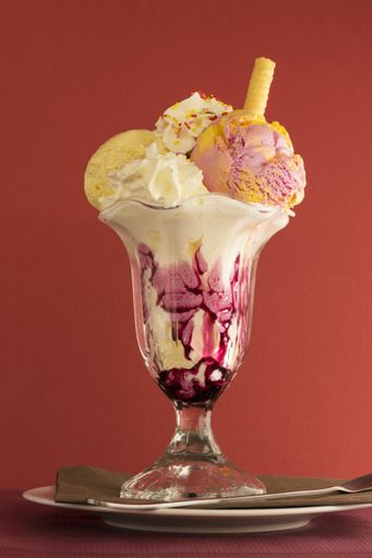 A vertical closeup shot of delicious-looking ice cream on an isolated red background