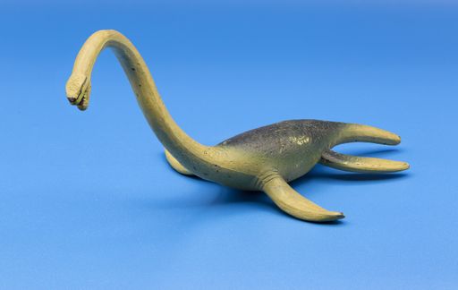 A closeup of a dinosaur toy isolated on a blue background