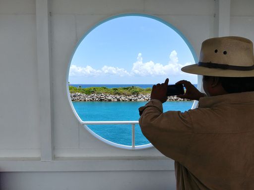 A man taking a picture of the sea of cozumel.
Un hombre tomando una foto del mar de cozumel.