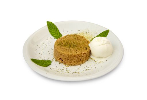 A closeup of a semolina dessert with ice cream served on a white plate isolated on a white background