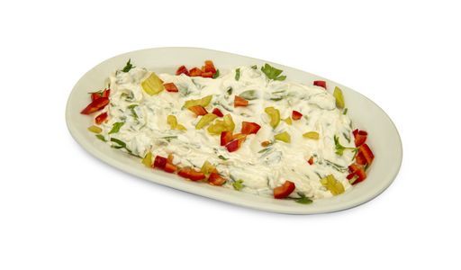 A closeup of a salad covered with sour cream and bell peppers isolated on a white background