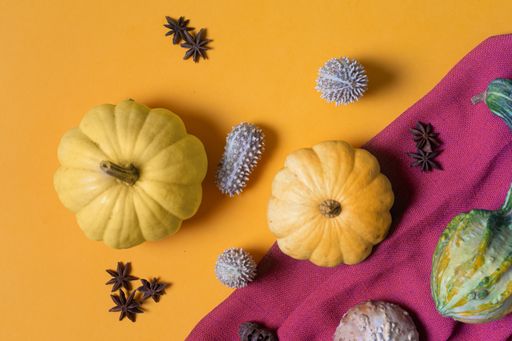 A top view of pumpkins on a yellow surface - concept: fall, autumn, harvest, Halloween