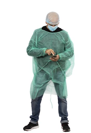 A vertical shot of a Hispanic male nurse checking his cellphone
