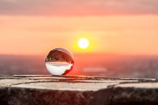 A closeup shot of a crystal ball with the scene of the beautiful sunset inside