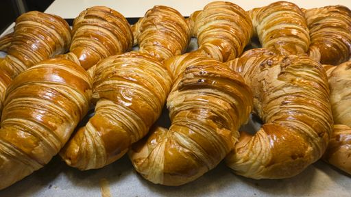 A closeup shot of freshly baked artisan croissants in the bakery