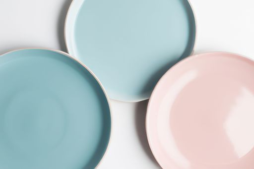 A closeup shot of blue and pink pastel plates on a white background