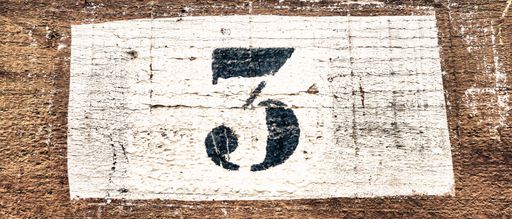 A closeup shot of number the 3 on a wooden background
