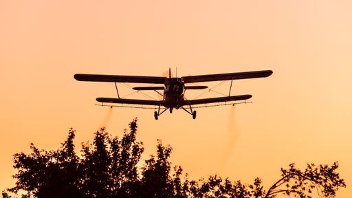 Cropduster plane spraying mosqitos in sunset