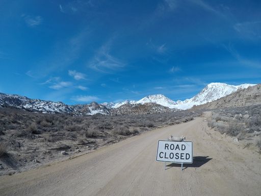 A closeup shot of a sign stating road closed in the middle of a road