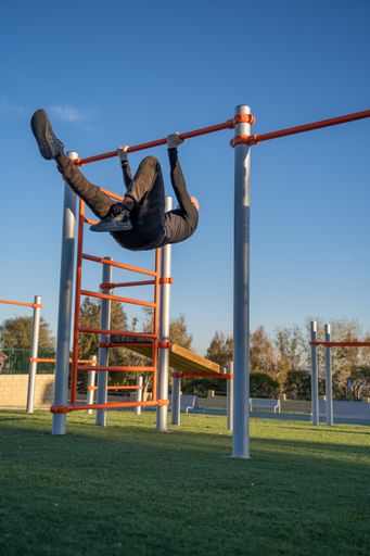 A young man doing his workout in the morning exercising on a horizontal bar