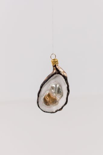 A hanging bauble in the shape of an oyster with pearls inside. The background is white